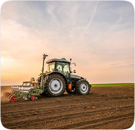 Tractor tilling field at sunset